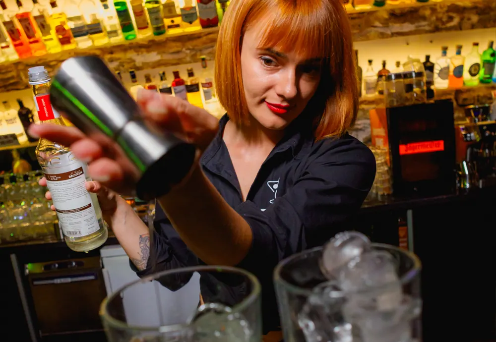 Barmanka připravuje koktejl v shakeru za barem ZONE Bar Praha